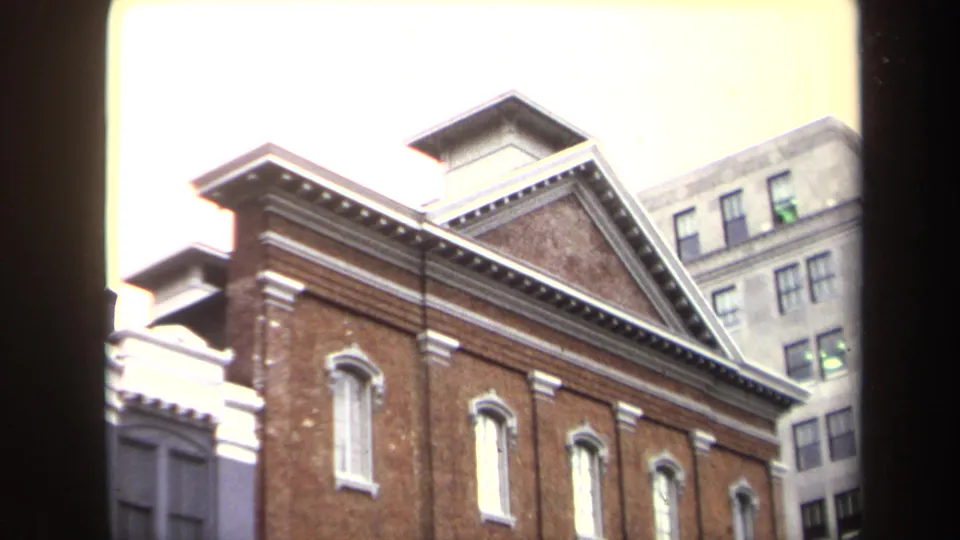 1970 Washington, DC home-movie view of Ford's Theatre facade, with red brick, white accents, and taller buildings behind it.
