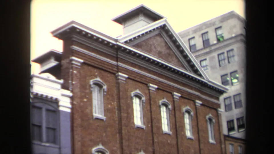 Street-level 8mm view of Ford's Theatre in Washington, DC, showing the brick facade, white cornice details, and background office building.