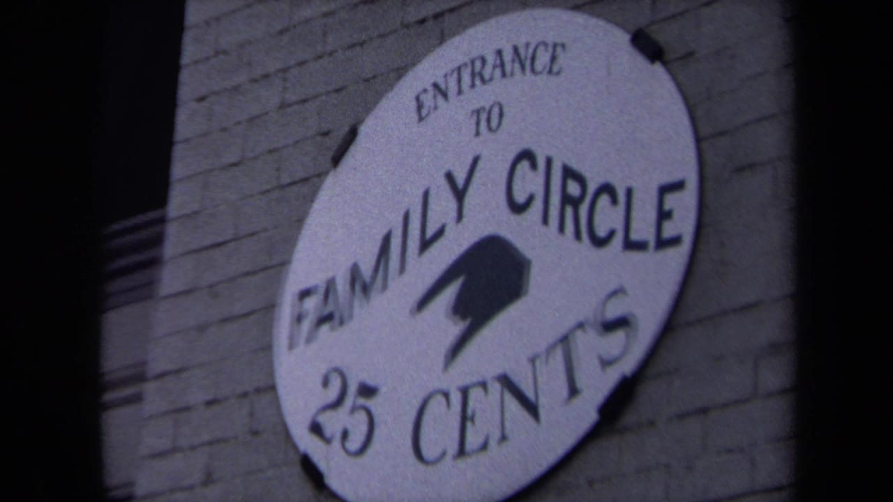 Round wall sign reading Entrance to Family Circle 25 Cents on a brick wall.