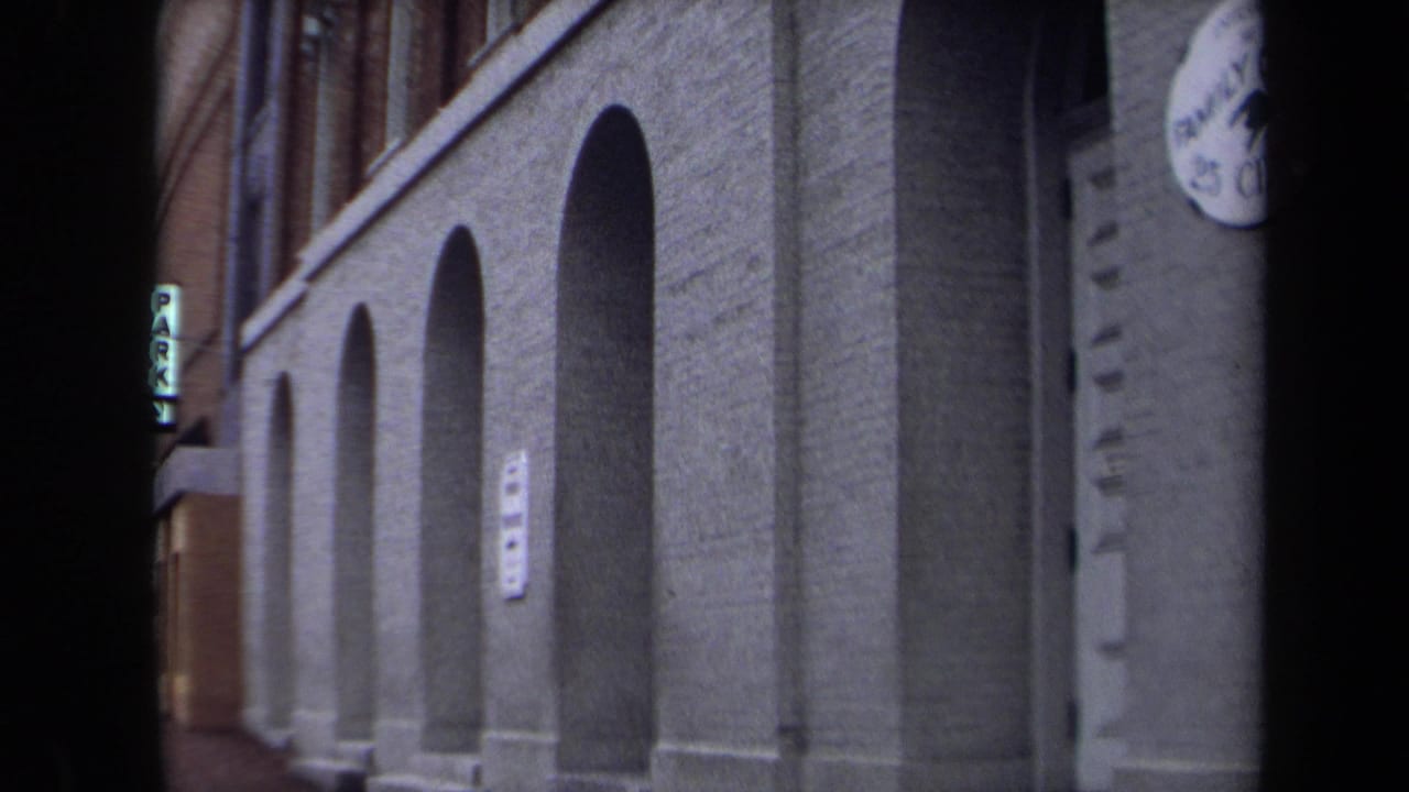 Arched brick building frontage with a vertical PARK sign partly visible.