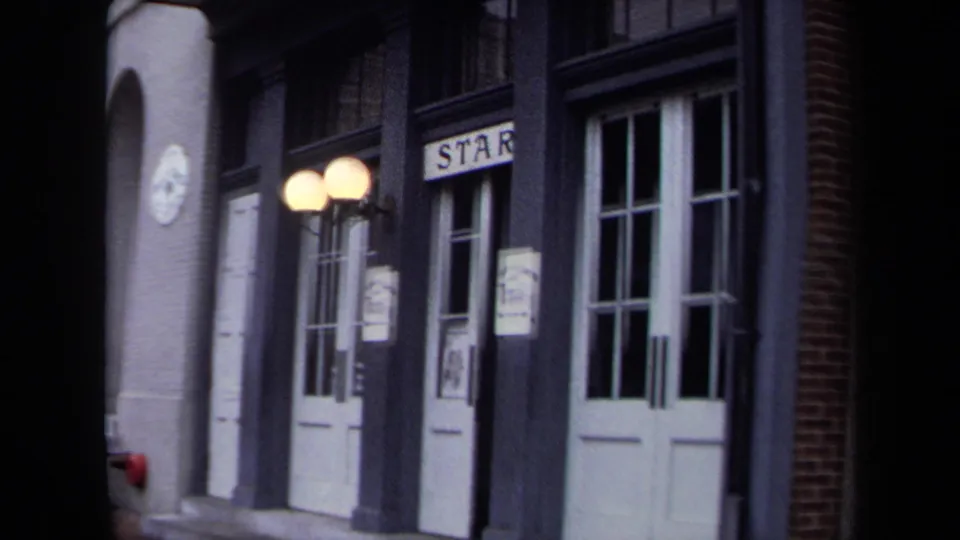1970 Washington, DC frame with white double doors, dark trim, globe lamps, posters, and a visible sign reading "STAR" above an entrance.