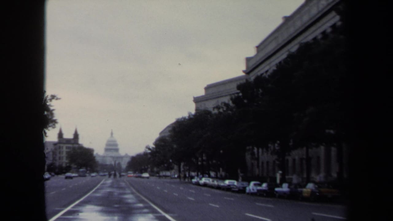 Wide avenue looking toward the U.S. Capitol in the distance under an overcast sky.