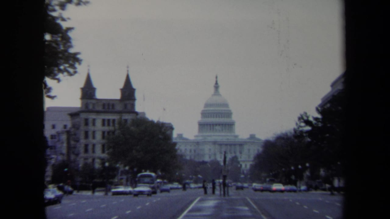 1970 Washington, DC street view looking toward the U.S. Capitol, with period cars, pedestrians, trees, and buildings in frame.