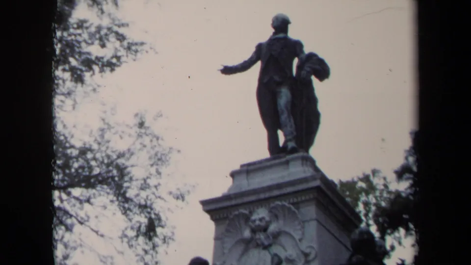 Washington, DC landmark view from 1970 showing a bronze standing figure statue on a pedestal against trees and pale sky.