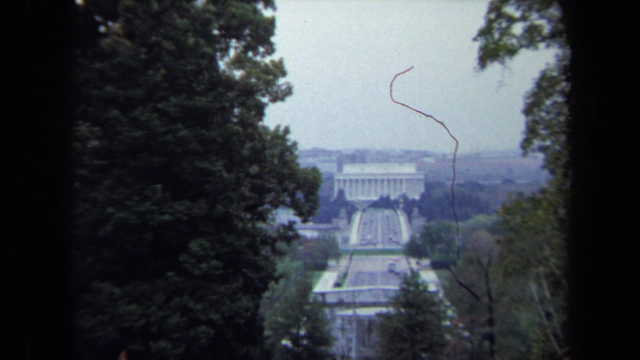 1970 Washington DC frame with the Lincoln Memorial and Reflecting Pool centered between tall trees during a slow zoom.