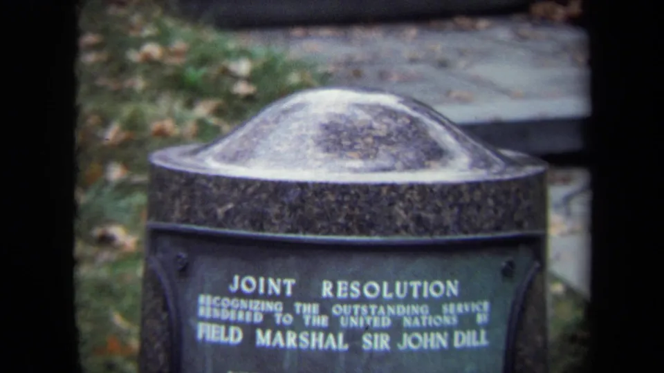 Cropped 1970 8mm view of the Sir John Dill memorial plaque, with large white lettering and soft film focus.