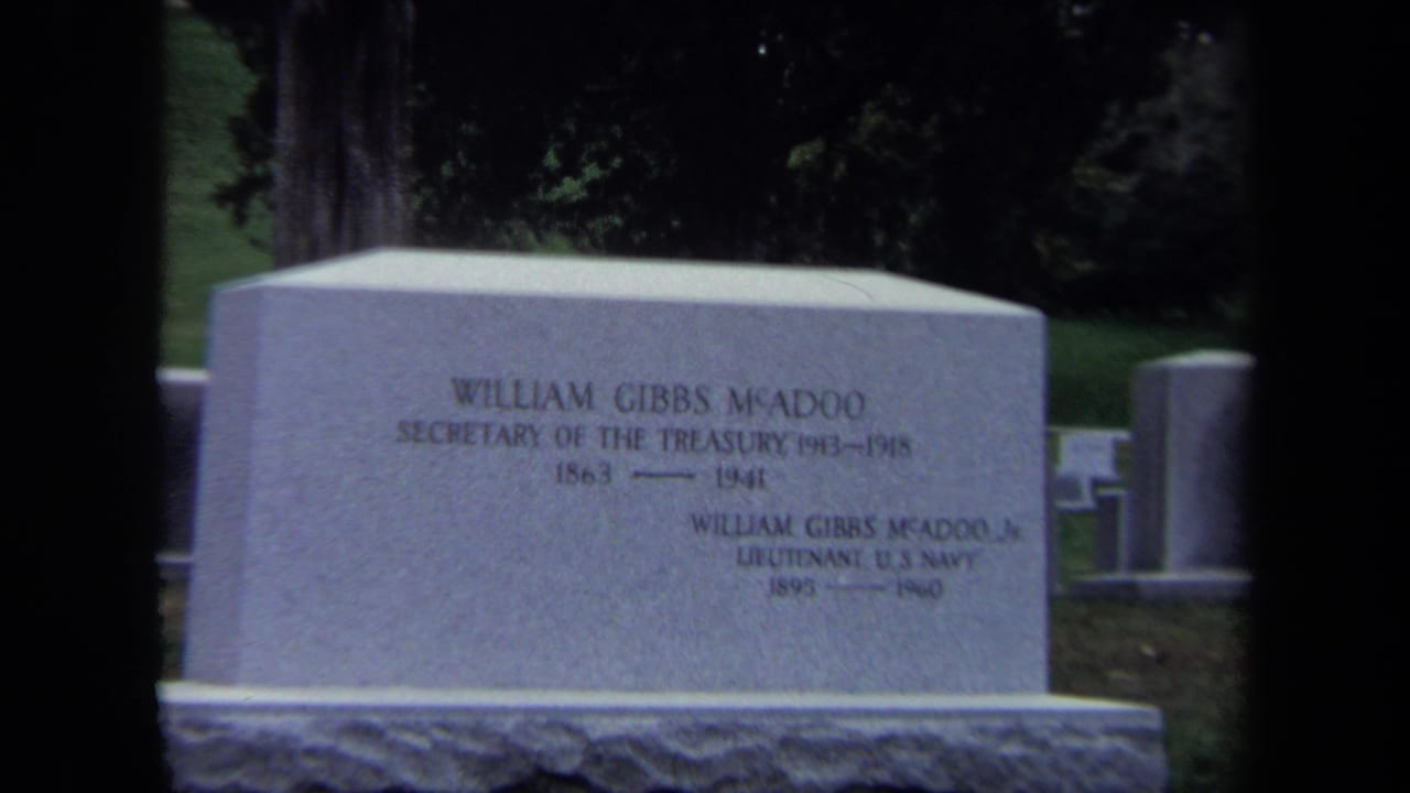 1970 Washington DC 8mm frame showing the William Gibbs McAdoo family headstone with grass and other cemetery markers nearby.