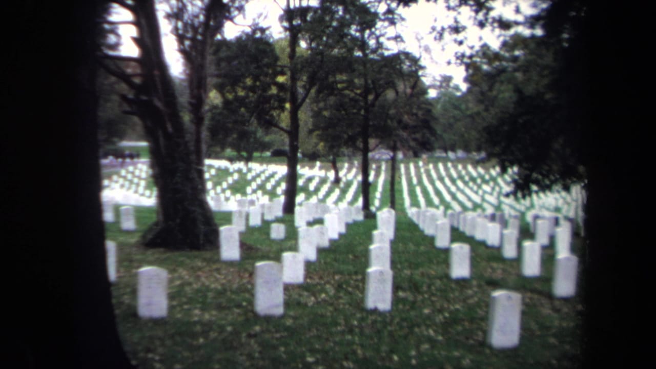 Washington DC cemetery grounds in 1970, showing orderly rows of white headstones framed by dark tree trunks.