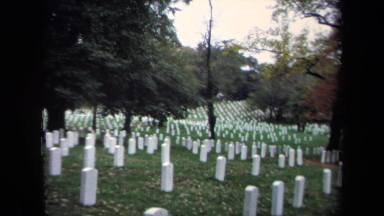 1970 Washington, DC cemetery view with white tombstones receding across a grassy hillside under mature trees.