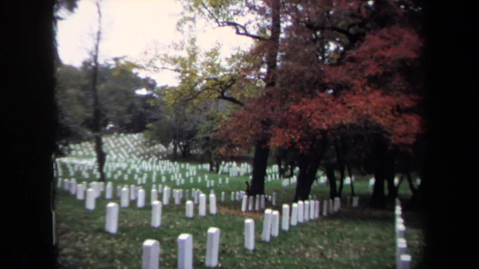 Washington, DC cemetery grounds in 1970 with uniform white markers, grass, mature trees, and red autumn foliage.