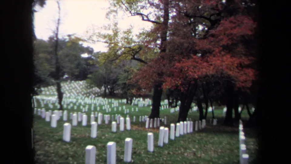 1970 Washington, DC cemetery view with rows of white headstones, grass, and trees showing red and yellow autumn foliage.