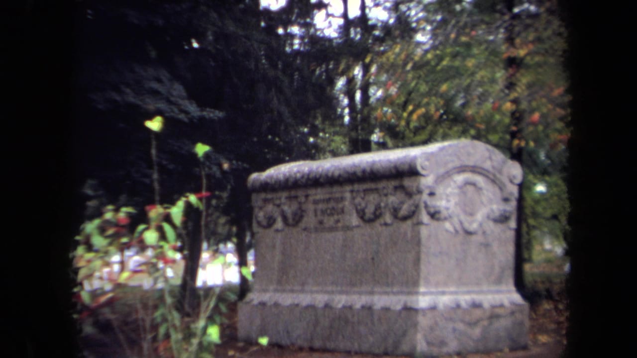 1970 Washington, DC 8mm frame showing an ornate cemetery tomb among trees and foliage.