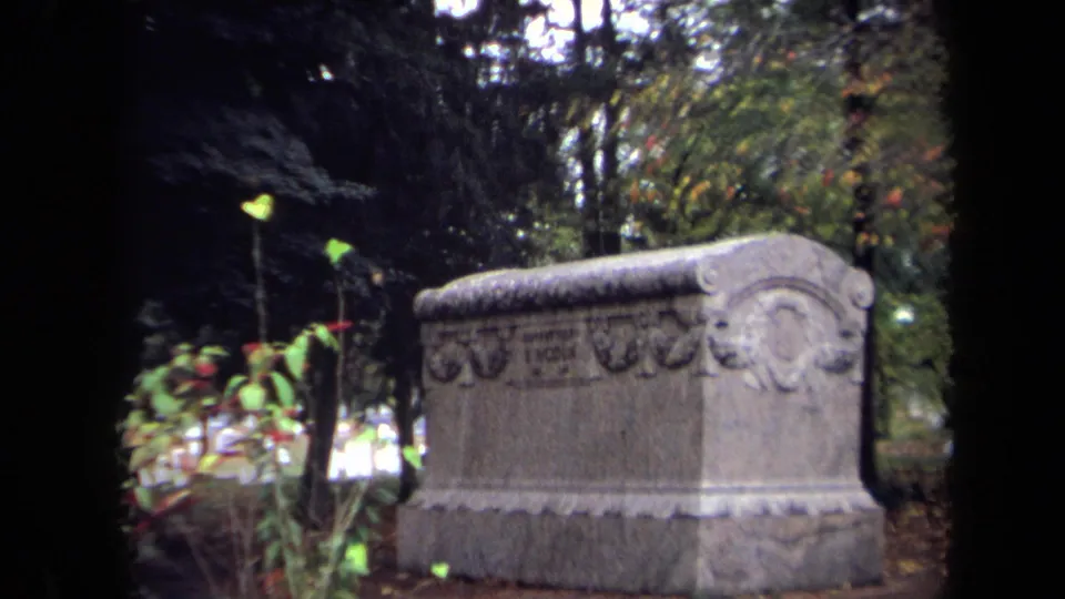 1970 Washington, DC 8mm frame showing an ornate cemetery tomb among trees and foliage.