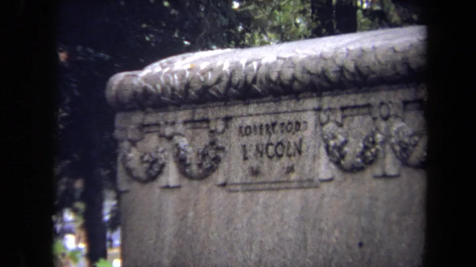 Angled 1970 cemetery frame emphasizing the Robert Todd Lincoln lettering and carved ornament on the tomb.