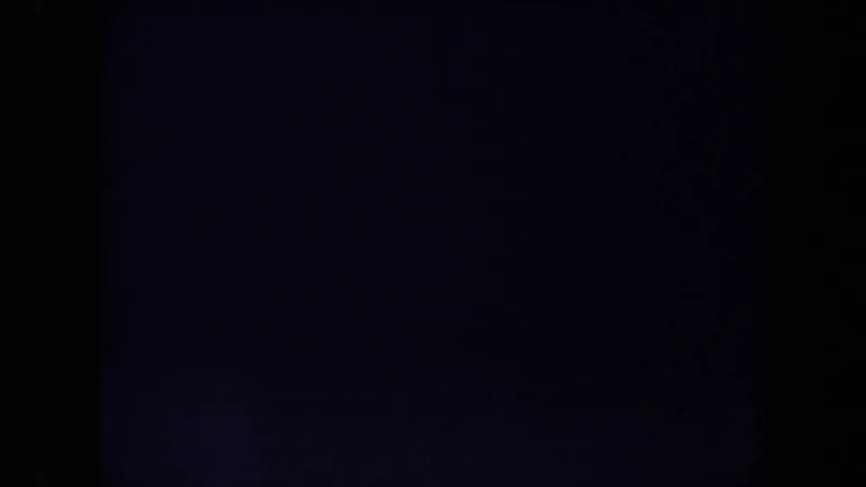 Dim 8mm frame with mostly dark exposure, faint surface texture, and visible film border areas.
