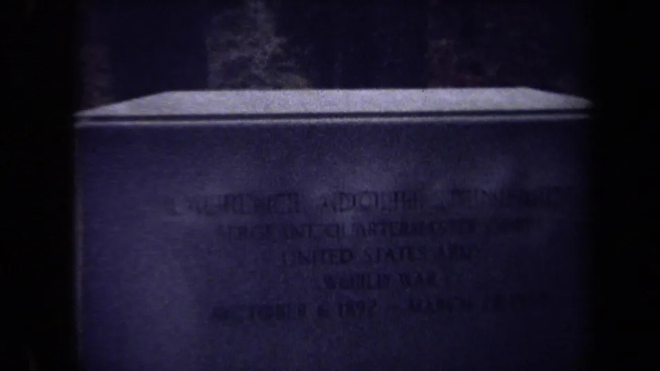 Dark 1970 Washington DC cemetery close-up showing a headstone face with faint, partly unreadable inscription.
