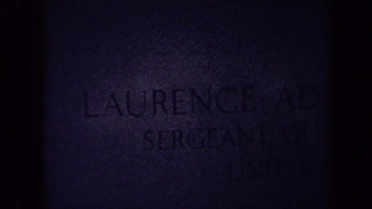 Dark 8mm frame from the 1970 Washington, DC cemetery clip, with part of Laurence Adolph Steinhardt's headstone faintly visible.