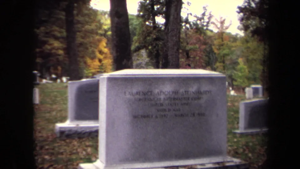 Wider 1970 8mm view of Laurence Adolph Steinhardt's headstone among autumn trees and other cemetery markers in Washington, DC.