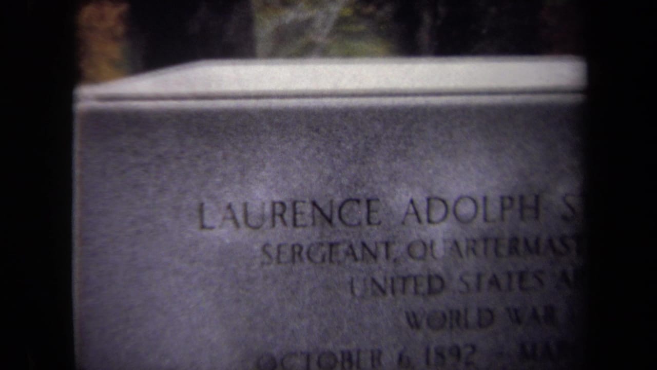1970 Washington, DC 8mm frame showing a close, soft-focus view of an engraved military tombstone for Laurence Adolph Steinhard.