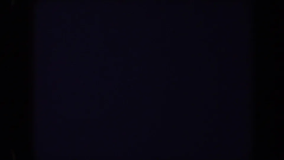 Dark 8mm frame edge with only a faint partial view of the cemetery scene in Washington, DC, 1970 footage.