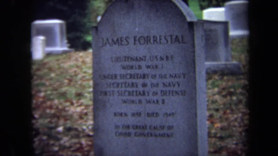 1970 Washington, DC cemetery frame with James Forrestal's headstone prominent and rows of pale markers in the background.