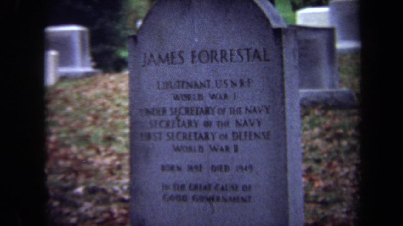 Close view of James Forrestal's rounded cemetery headstone among other grave markers.