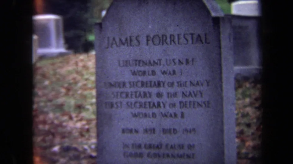 Close 8mm view of the James Forrestal tombstone in Washington, DC, showing the inscription and adjacent grave markers.