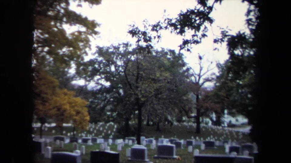 Wide 1970 8mm cemetery view in Washington, DC, with rows of headstones spread across a tree-lined lawn.