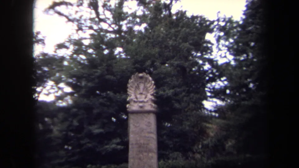 Closer 1970 Washington, DC frame of the monument top, with a carved eagle-like emblem set against park foliage.
