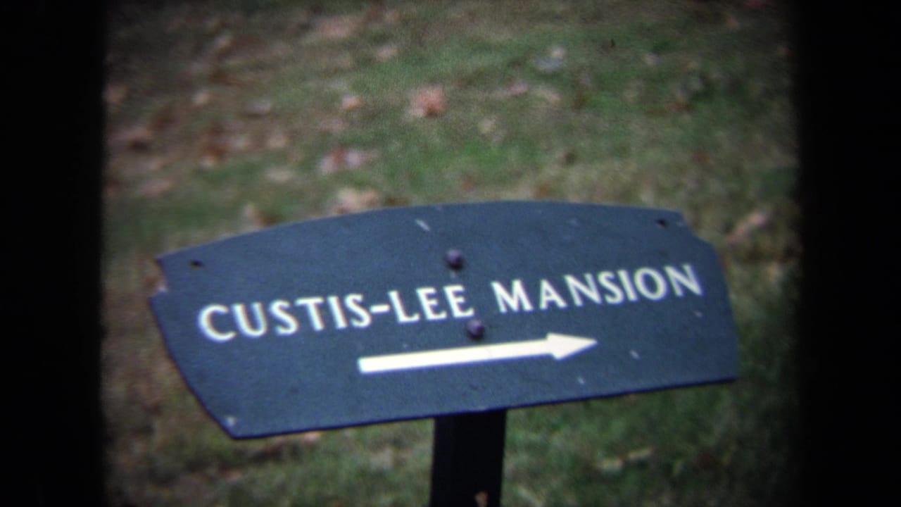 1970 Washington-area 8mm frame showing a Custis-Lee Mansion directional sign set against grass and leaves.
