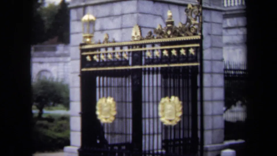 The 8mm frame moves closer to the Washington, DC gate, emphasizing gold crests, iron bars, and formal stone architecture.