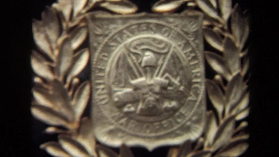 The final frame shows a soft 8mm close-up of the gold War Office seal and laurel wreath detail in Washington, DC.