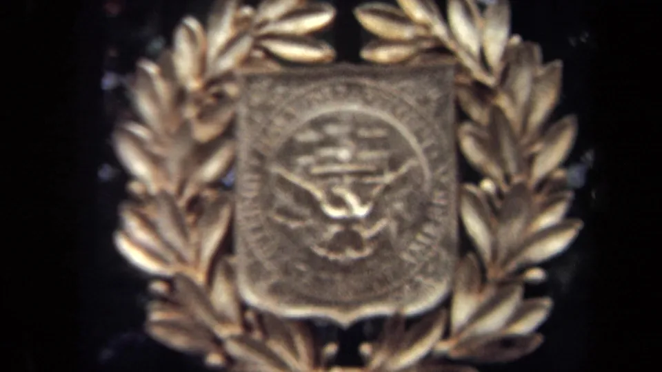 1970 Washington, DC 8mm frame showing a closer zoom on the raised metal emblem and surrounding laurel leaves.