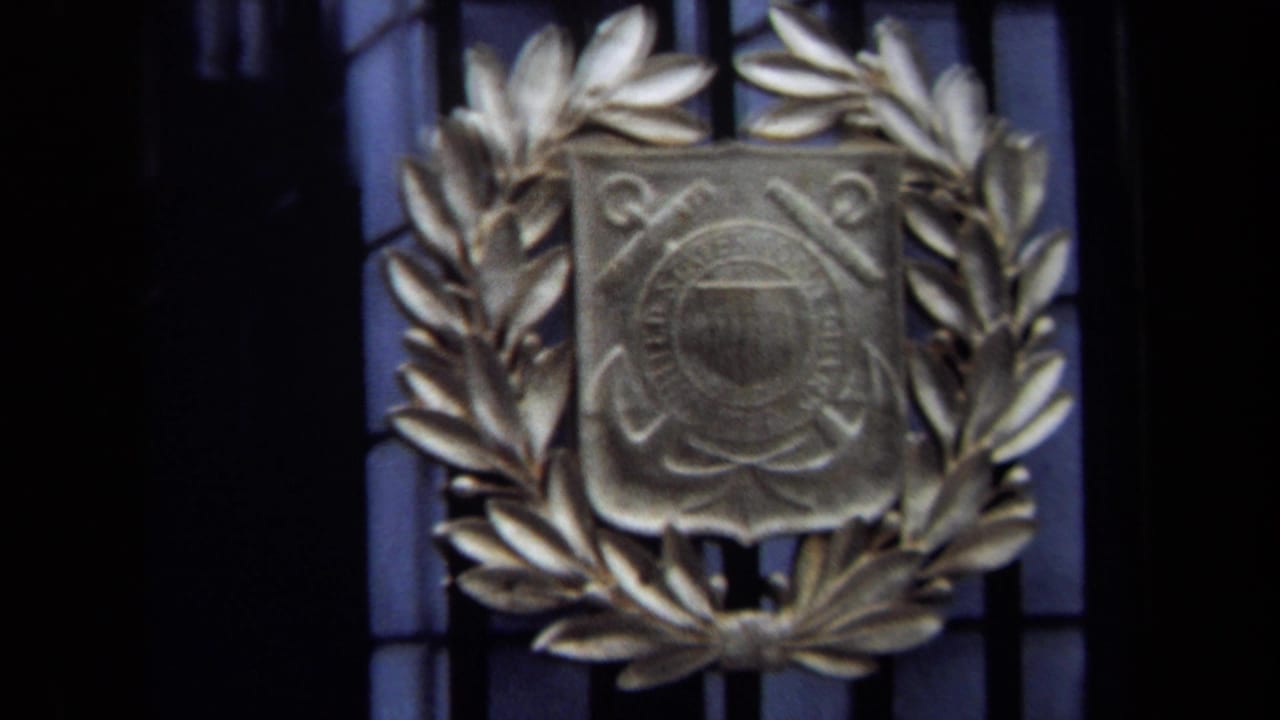 1970 Washington, DC 8mm frame showing a close view of a metal U.S. Coast Guard emblem set inside a laurel wreath.