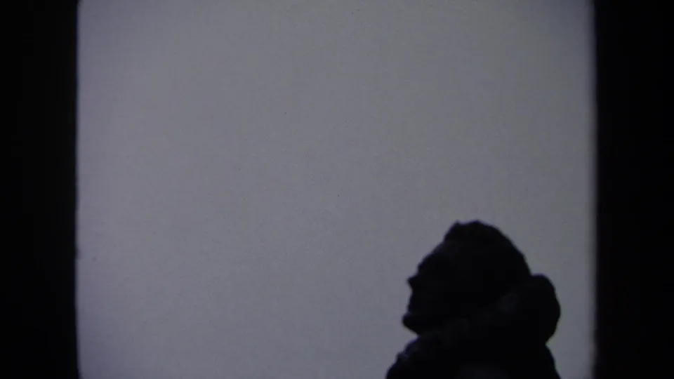 A dark side-profile silhouette remains visible near a wall edge in this 1970 Washington, DC home-movie frame.