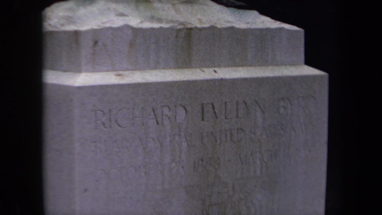 1970 Washington, DC home-movie frame showing the upper portion of Richard Evelyn Byrd's engraved gravestone in soft 8mm focus.