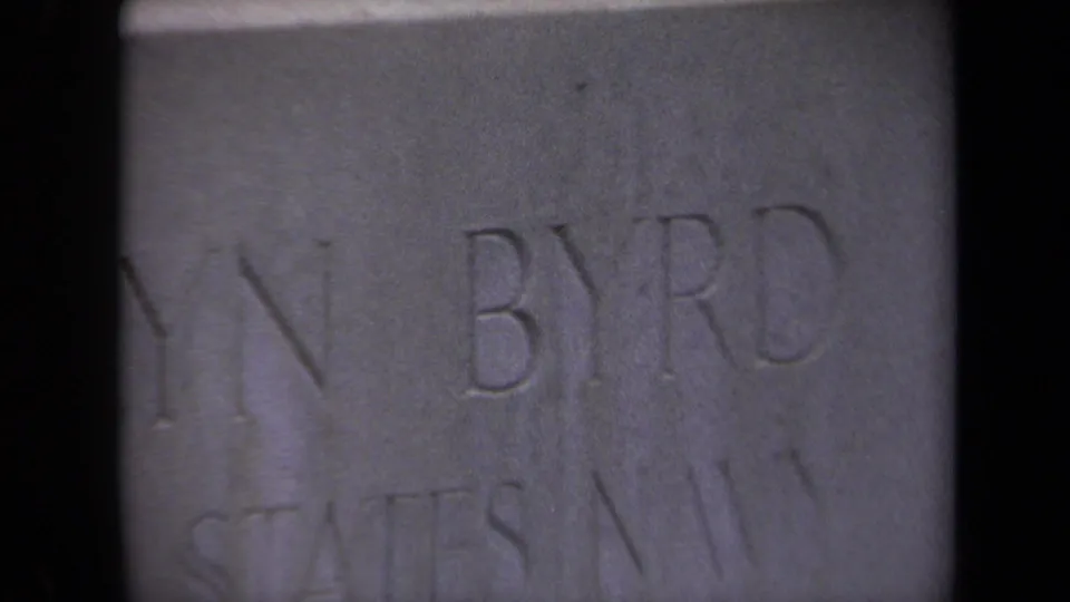 Soft 8mm close-up from 1970 showing the lower inscription area of Richard Evelyn Byrd's gravestone in Washington, DC.