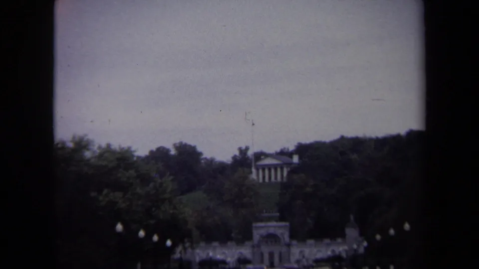 1970 Washington, DC 8mm view looking past trees and lampposts toward a distant neoclassical structure.