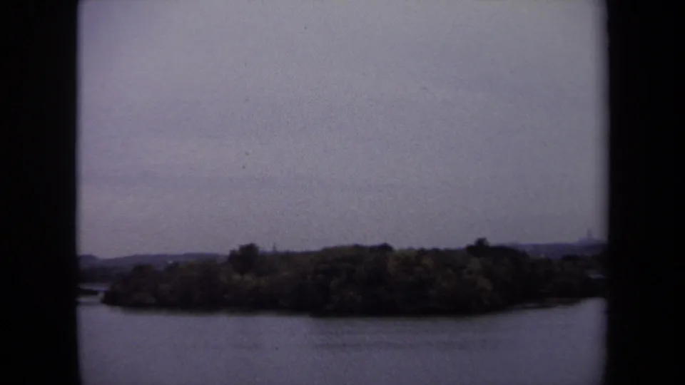 A wooded riverbank or island appears across the water in this 1970 Washington, DC area 8mm frame.
