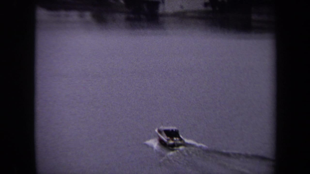 Motorboat traveling on a wide waterway with a wake trailing behind.