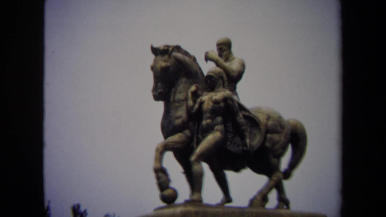 Close 1970 8mm view of an equestrian statue in Washington DC, with the rider and horse silhouetted against an overcast sky.