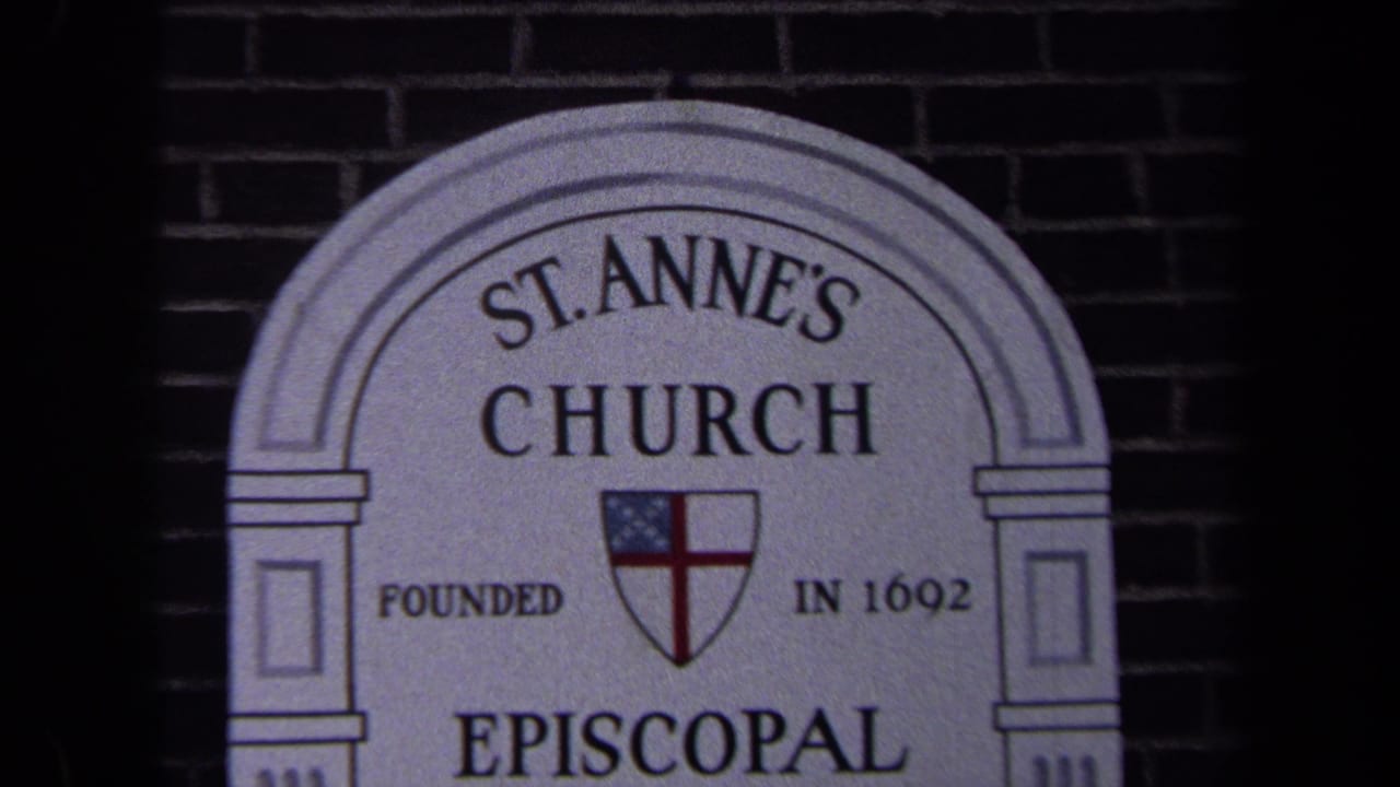 Close 8mm view of the St. Anne's Church sign in Washington, DC, with the Episcopal shield and inscription visible against brick.