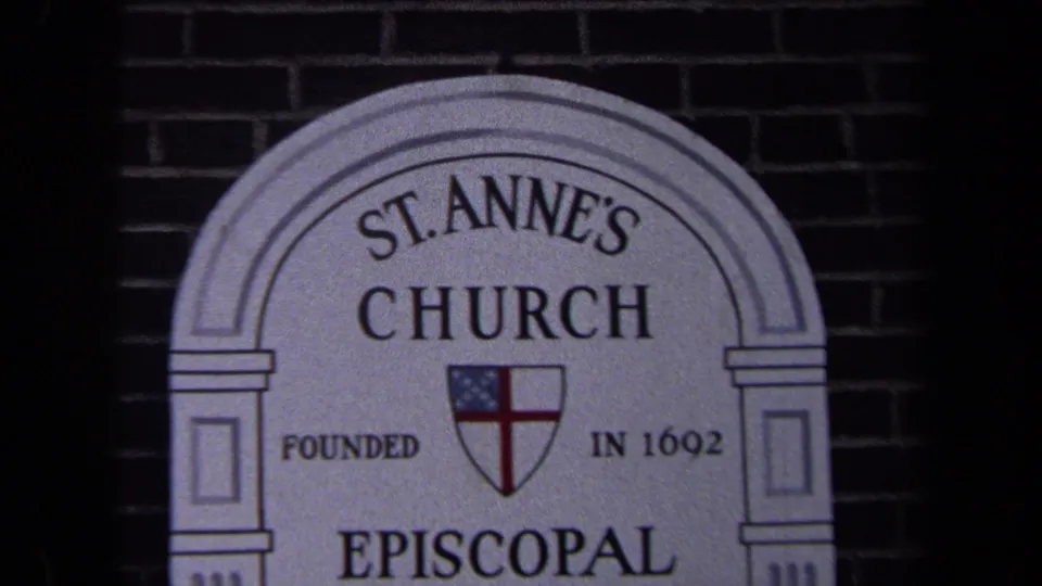 Close 8mm view of the St. Anne's Church sign in Washington, DC, with the Episcopal shield and inscription visible against brick.