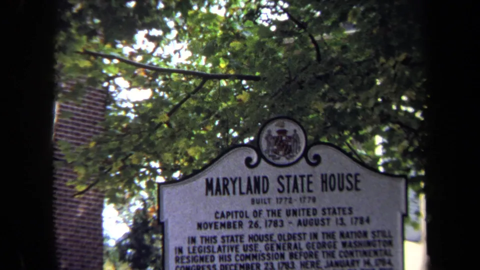 Tight 8mm frame of the Maryland State House marker, with its title readable beneath a leafy canopy.