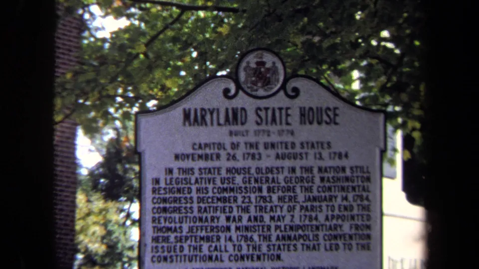 The marker fills the frame, with readable Maryland State House heading, leafy branches above, and dark film-edge shadowing.