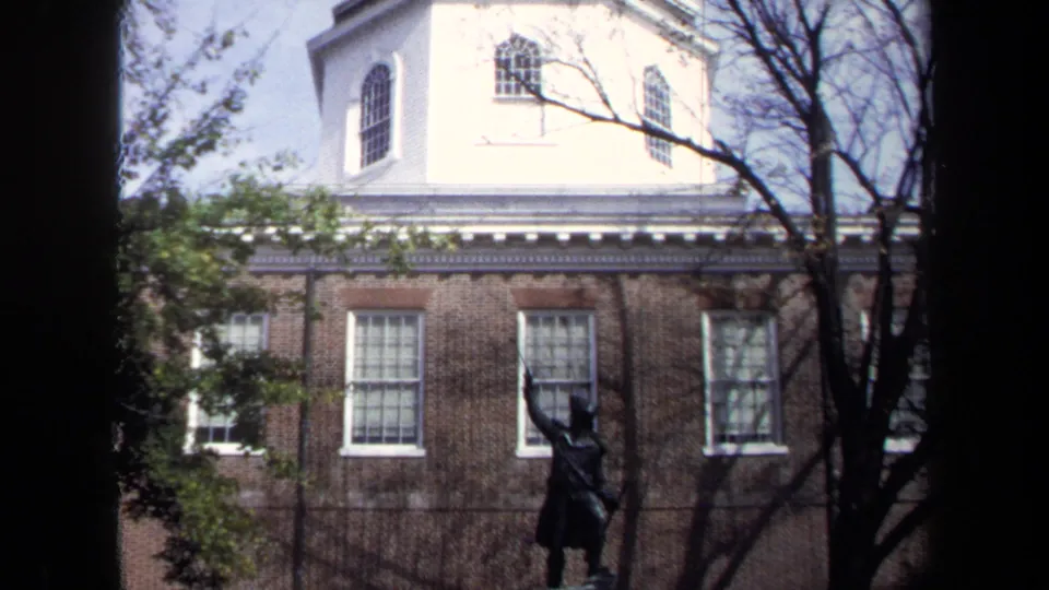 1970 Washington, DC frame tilting upward from the DeKalb statue to a brick building topped by a white cupola.