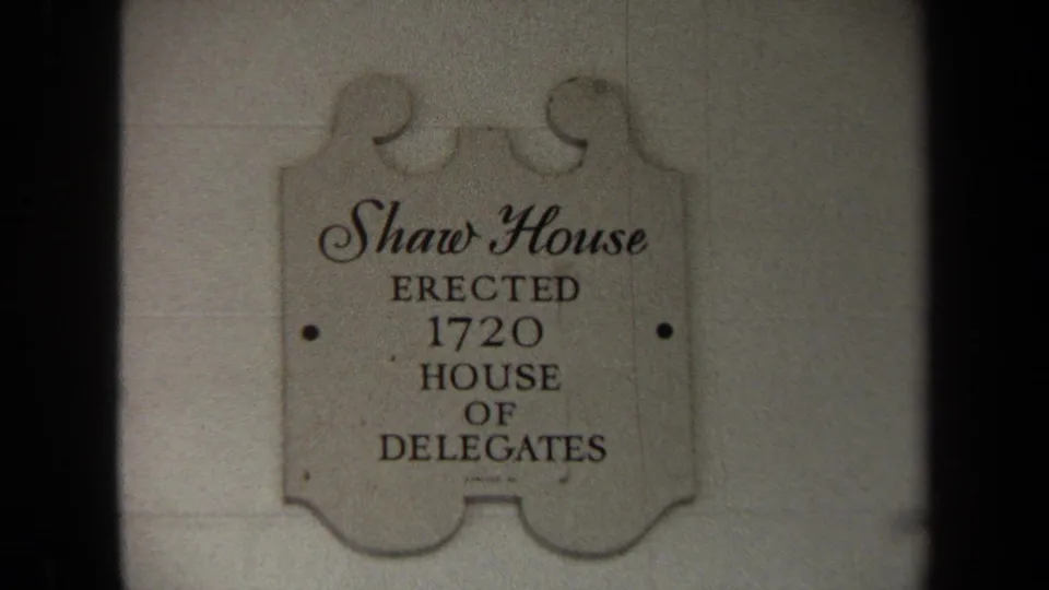 Tighter 8mm frame of the Shaw House plaque, with readable text and soft exposure on the surrounding wall.