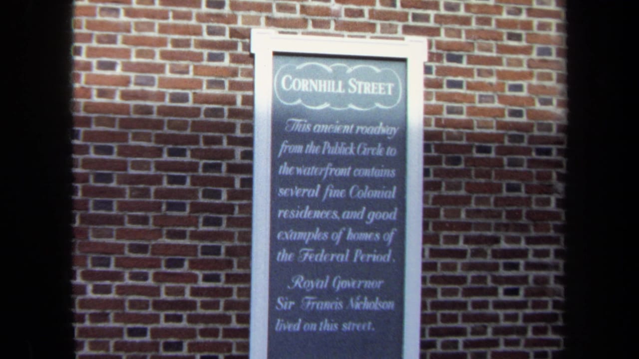 1970 Washington, DC 8mm frame showing a Cornhill Street historical marker mounted on a red brick wall.