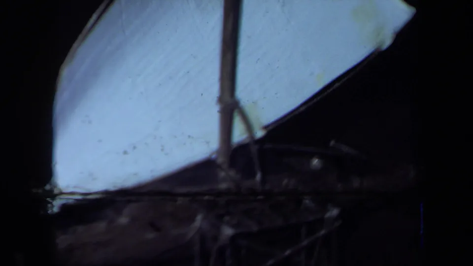 1971 California 8mm frame showing a dark tabletop with a pale sail-like form and partial pineapple centerpiece visible at the edge.