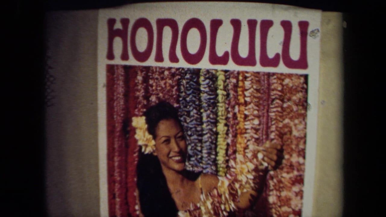 1971 8mm frame of a Honolulu poster with a smiling woman pictured among colorful leis.